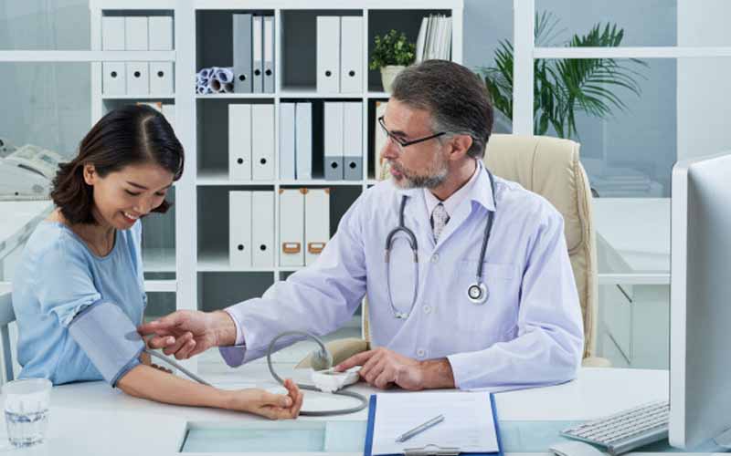 Doctor measuring Blood Pressure of the patient