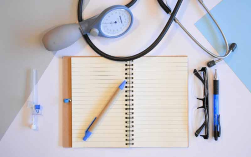 A notepad and a pen next to a stethoscope
