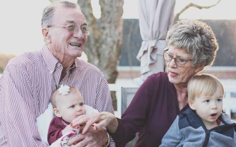 Elder couple holding babies