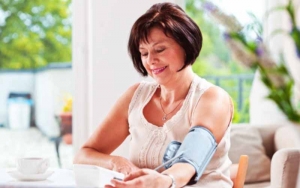 A woman measuring her blood pressure at home