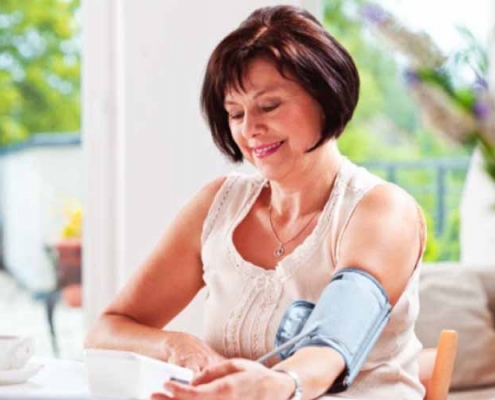 A woman measuring her blood pressure at home