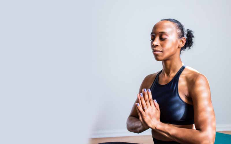 Lady meditating with eyes closed and hands together