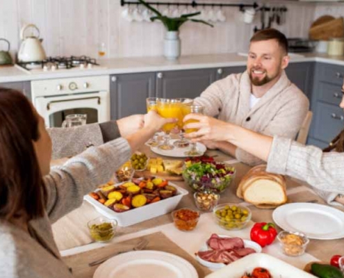 People clinking glasses while sharing a meal