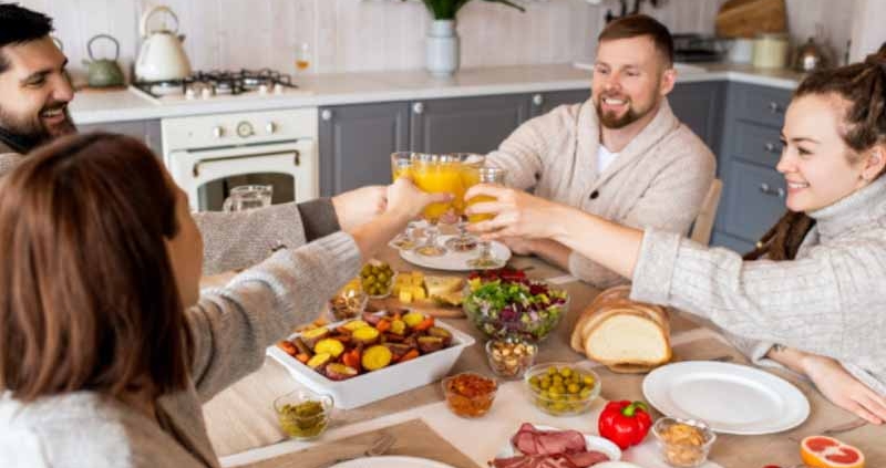 People clinking glasses while sharing a meal