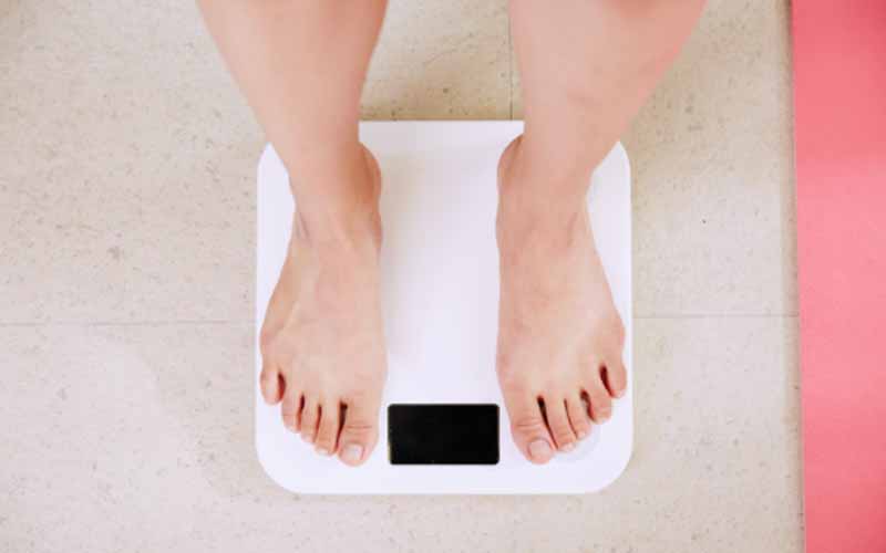 Person standing on a white digital weighing scale