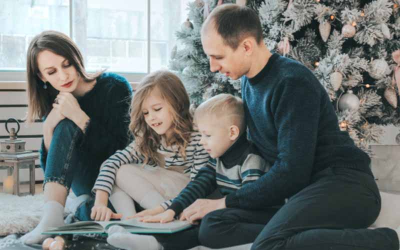 Family seated looking at a book