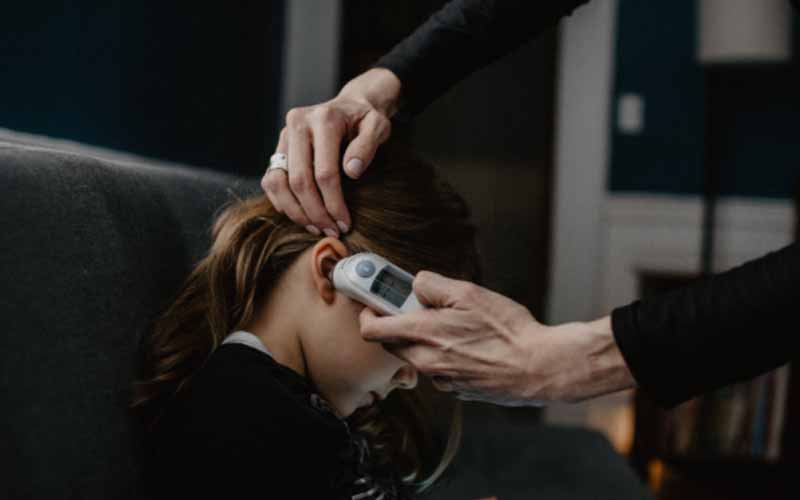 Girl having her temperature checked