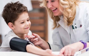 Lady checking a child’s blood pressure levels