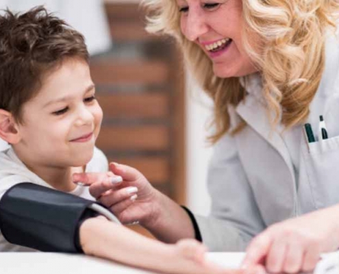 Lady checking a child’s blood pressure levels