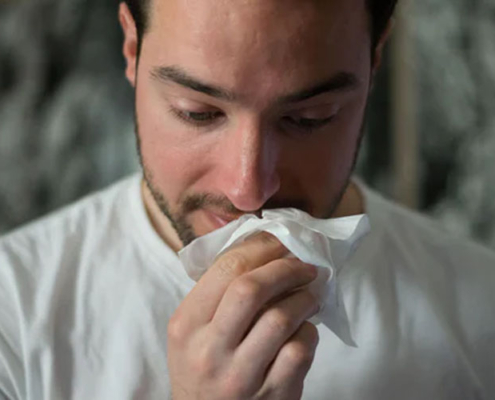 Man wiping his nose with a tissue